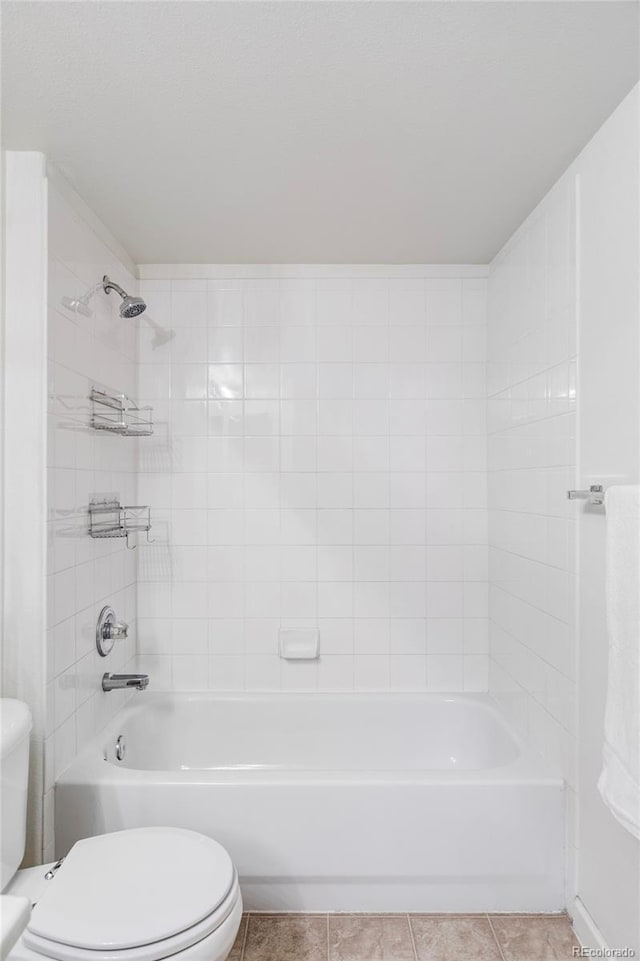 bathroom featuring toilet, tile patterned flooring, and washtub / shower combination