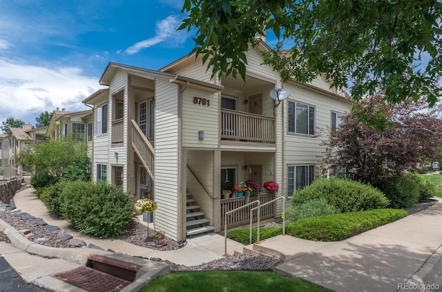 view of front of house with stairs and a balcony