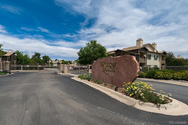 view of street with a residential view, a gate, a gated entry, and curbs