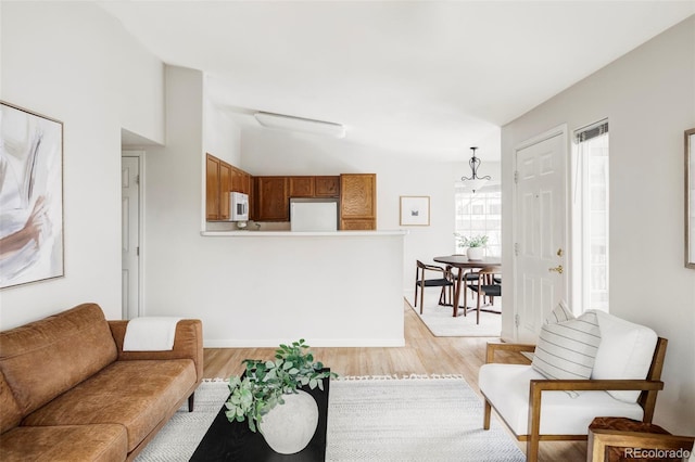 living area with light wood-type flooring and lofted ceiling