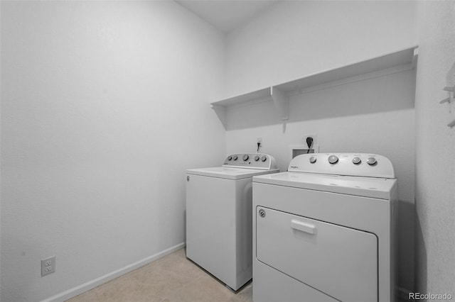 washroom with washer and dryer and baseboards