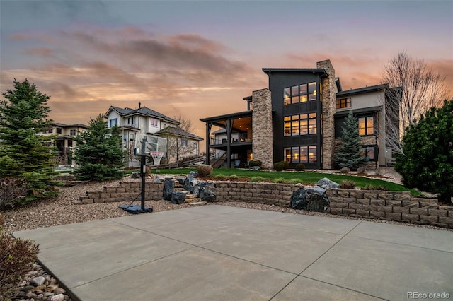 exterior space featuring a balcony, a patio, stairway, and stone siding