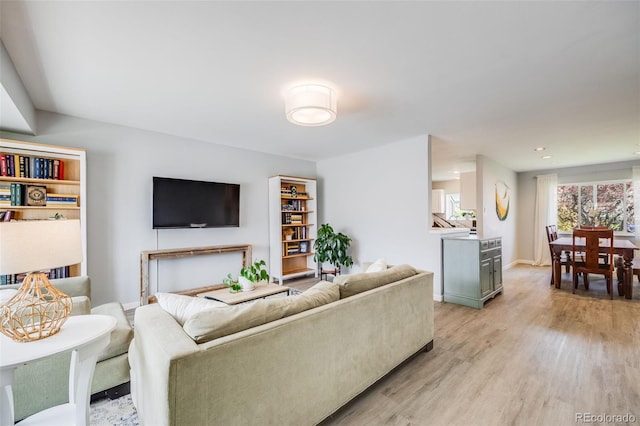 living room with recessed lighting, baseboards, and light wood finished floors