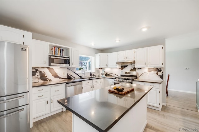 kitchen with a sink, dark countertops, backsplash, and stainless steel appliances