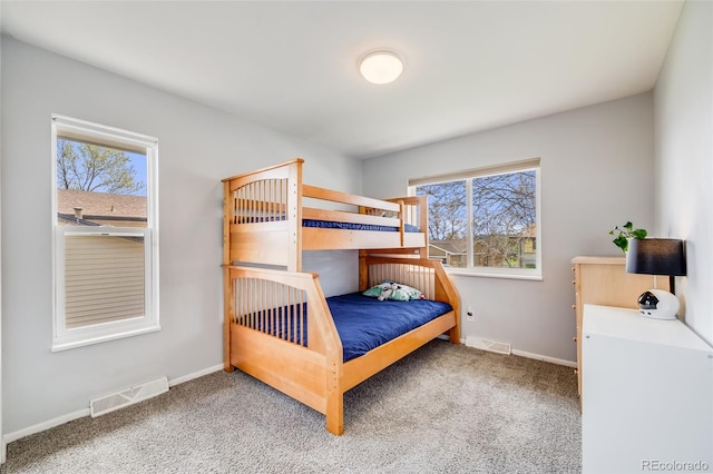 carpeted bedroom with visible vents and baseboards