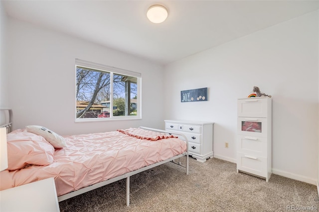 bedroom with light colored carpet and baseboards