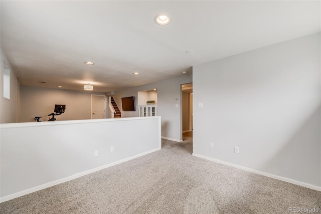 spare room with carpet floors, recessed lighting, baseboards, and stairway