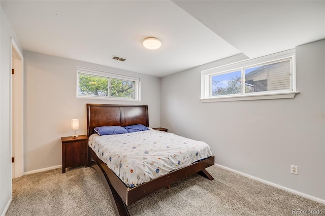 bedroom featuring visible vents, baseboards, and light colored carpet