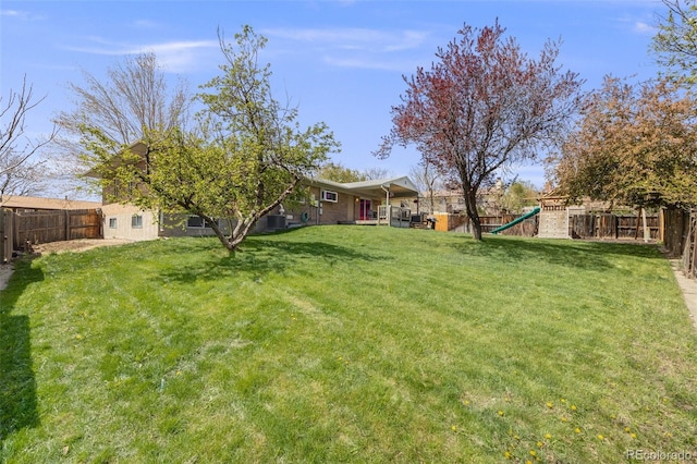 view of yard with a fenced backyard and a playground