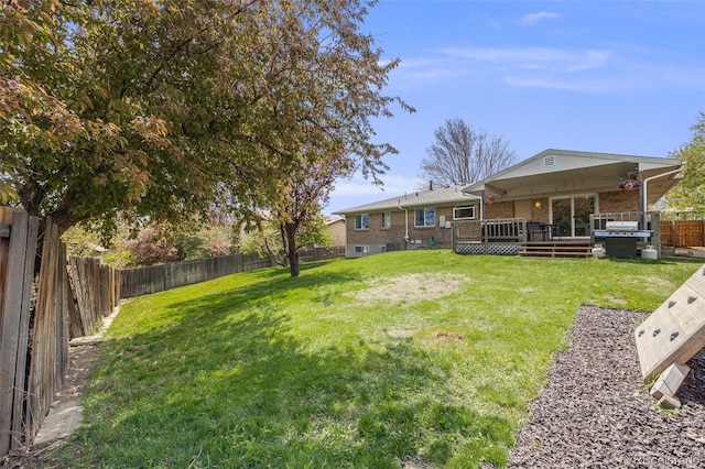 view of yard with a fenced backyard and a wooden deck
