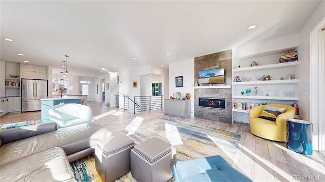 885 Delechant Dr, Erie, CO 80516 - living area featuring light wood finished floors, recessed lighting, a tile fireplace, and built in features