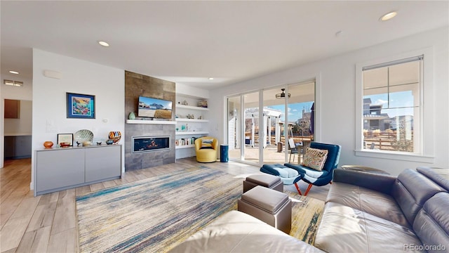 885 Delechant Dr, Erie, CO 80516 - living area with built in features, recessed lighting, light wood-style flooring, and a tiled fireplace