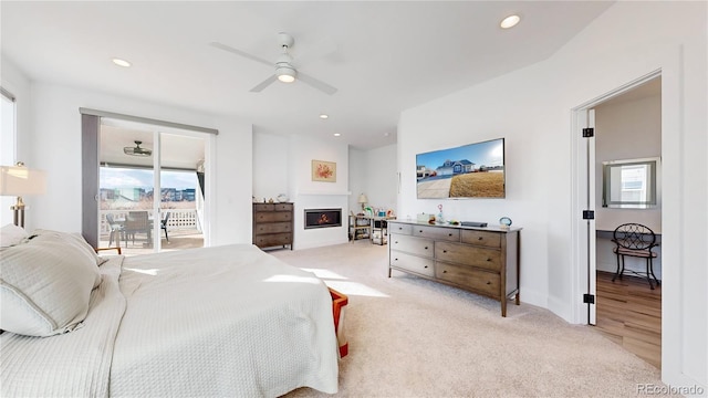 885 Delechant Dr, Erie, CO 80516 - bedroom with access to exterior, recessed lighting, a warm lit fireplace, and light colored carpet