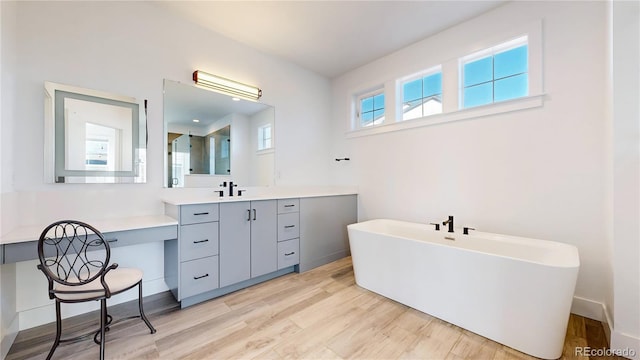 885 Delechant Dr, Erie, CO 80516 - bathroom with a soaking tub, wood finished floors, and vanity