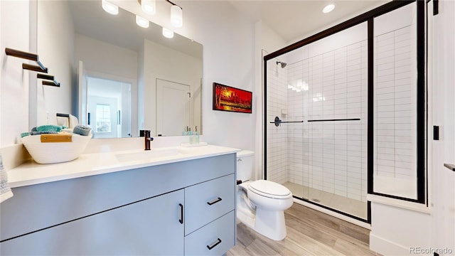 885 Delechant Dr, Erie, CO 80516 - bathroom featuring toilet, wood finished floors, vanity, and a shower stall