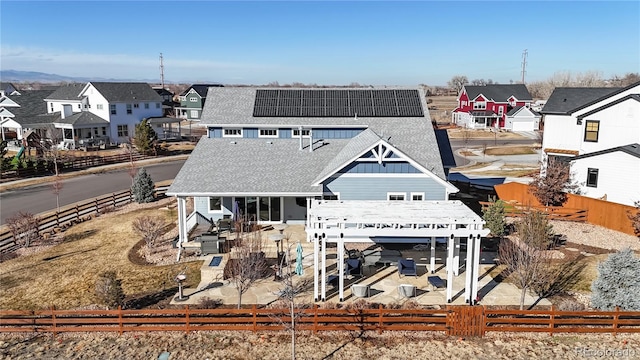 885 Delechant Dr, Erie, CO 80516 - view of front of house featuring a shingled roof, a fenced backyard, a residential view, roof mounted solar panels, and a pergola