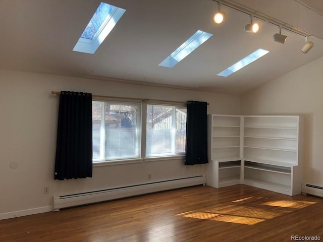 unfurnished room with lofted ceiling, baseboard heating, and wood finished floors