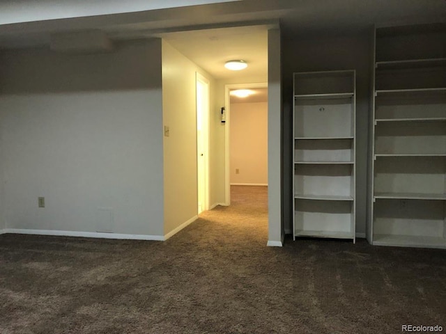 interior space with dark colored carpet and baseboards