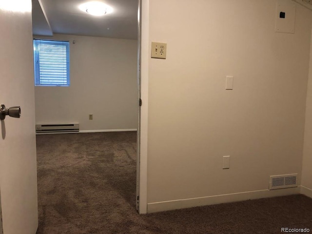 corridor with dark colored carpet, baseboards, visible vents, and baseboard heating