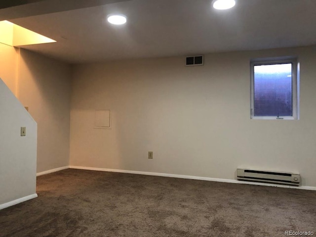 below grade area featuring baseboards, visible vents, baseboard heating, dark carpet, and recessed lighting