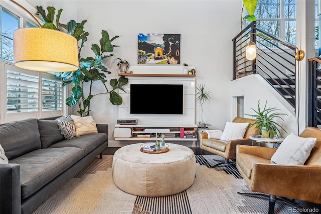 living room featuring stairway, a high ceiling, and wood finished floors