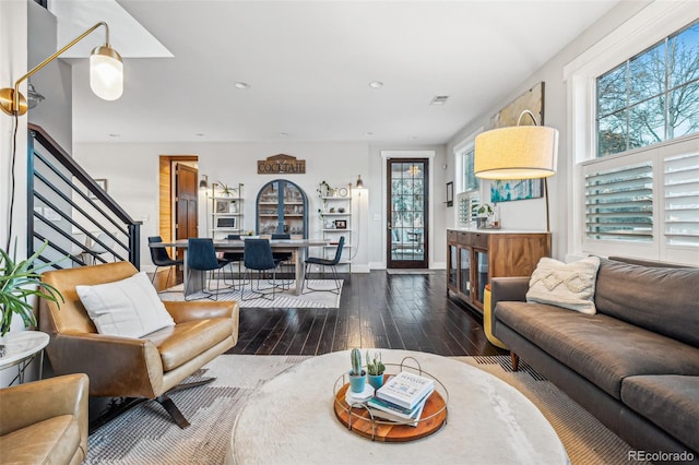 living area featuring baseboards, visible vents, stairway, wood finished floors, and recessed lighting