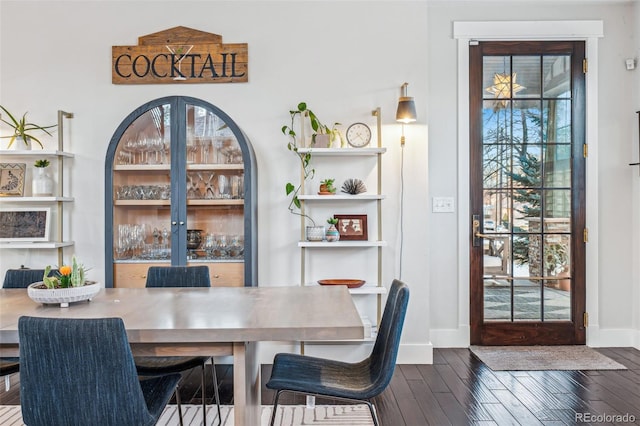 dining area featuring dark wood finished floors and baseboards