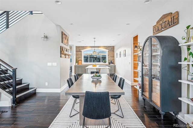 dining area featuring recessed lighting, dark wood-style flooring, baseboards, and stairs