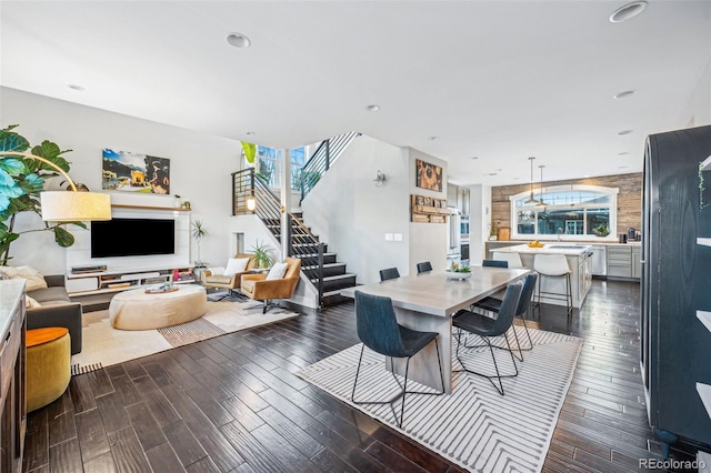 dining area with a healthy amount of sunlight, dark wood-style floors, and stairway