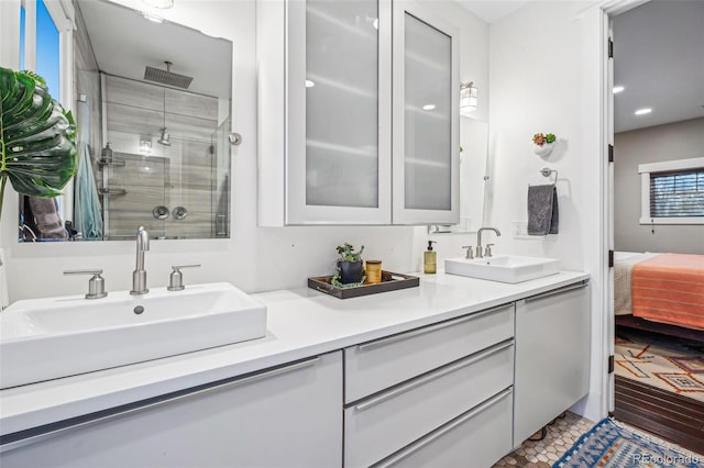 ensuite bathroom with connected bathroom, a stall shower, a sink, and double vanity