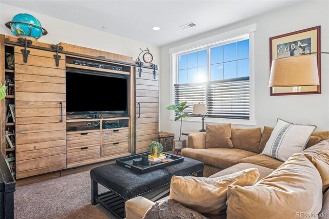 living area with a barn door, carpet, visible vents, and recessed lighting