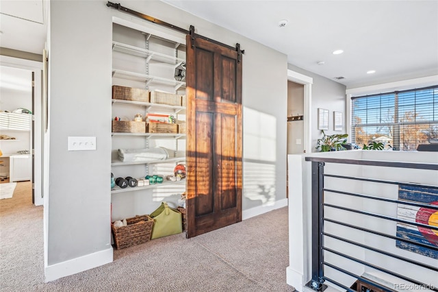 hallway with carpet, a barn door, baseboards, and recessed lighting