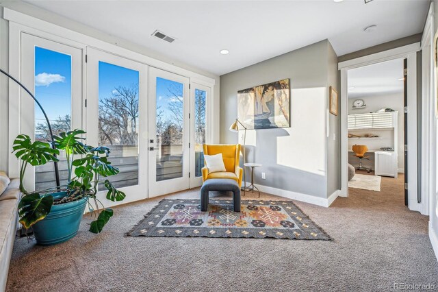 living area with carpet floors, french doors, visible vents, and baseboards