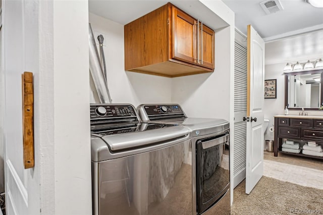 laundry area featuring cabinet space, visible vents, independent washer and dryer, carpet, and a sink