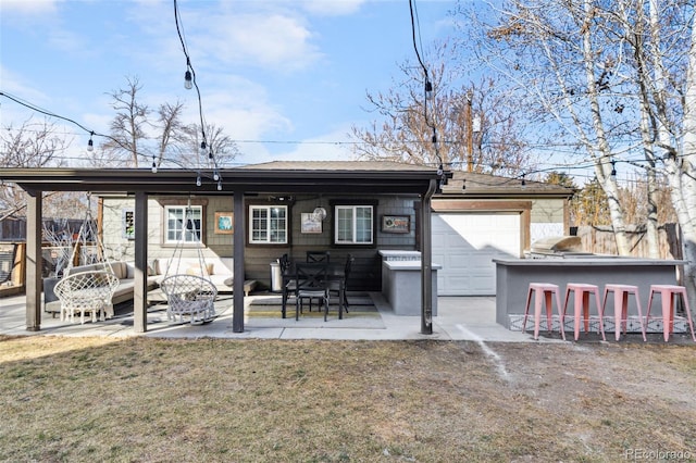 rear view of house with a yard, outdoor dry bar, and a patio