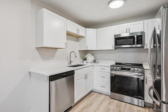 9380 E Center Ave Unit 8A, Denver, CO 80247 - kitchen featuring appliances with stainless steel finishes, light countertops, white cabinetry, and light wood-style floors