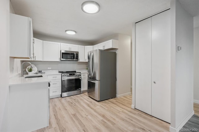 9380 E Center Ave Unit 8A, Denver, CO 80247 - kitchen featuring appliances with stainless steel finishes, light countertops, light wood-type flooring, and white cabinetry