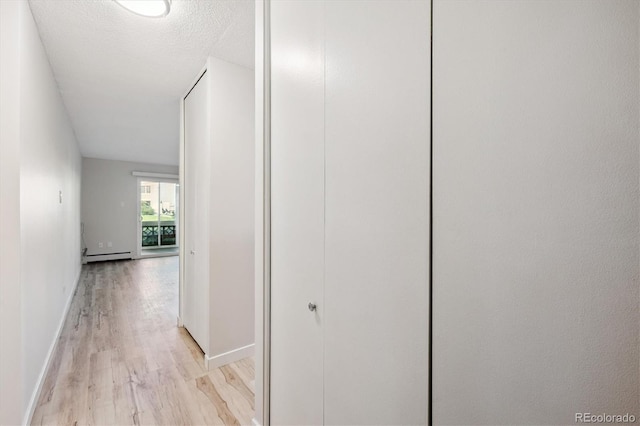 9380 E Center Ave Unit 8A, Denver, CO 80247 - corridor with light wood-style flooring, a baseboard radiator, and a textured ceiling