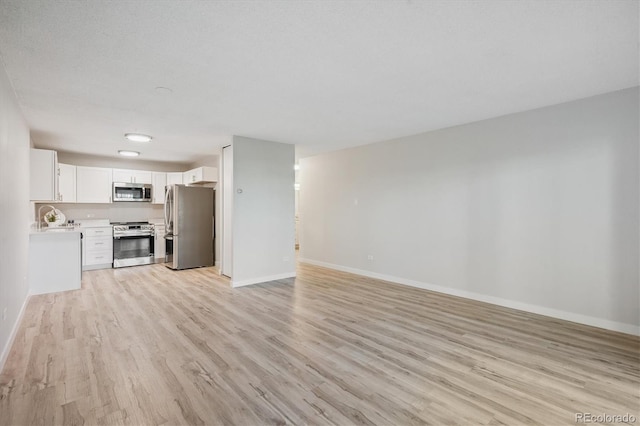 9380 E Center Ave Unit 8A, Denver, CO 80247 - unfurnished living room featuring light wood finished floors and baseboards