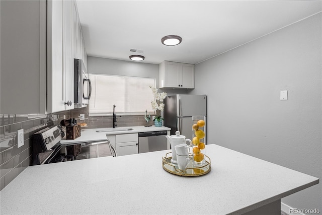 kitchen with white cabinetry, sink, kitchen peninsula, and stainless steel appliances