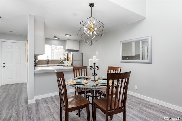 dining space with an inviting chandelier and light hardwood / wood-style floors