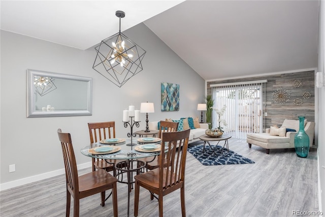 dining area with an inviting chandelier, lofted ceiling, and hardwood / wood-style floors