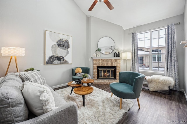 living room with ceiling fan, dark wood-type flooring, lofted ceiling, and a fireplace