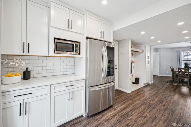 kitchen with white cabinets, stainless steel appliances, dark hardwood / wood-style floors, and backsplash