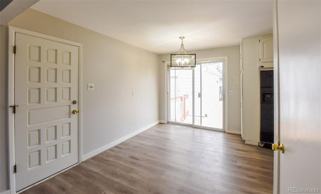 foyer with an inviting chandelier and light hardwood / wood-style flooring