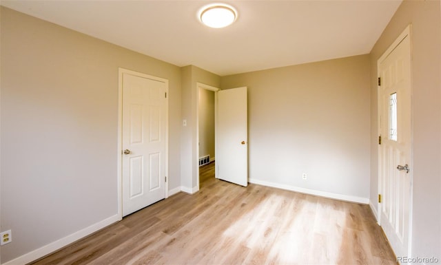 unfurnished bedroom with light hardwood / wood-style flooring and a closet