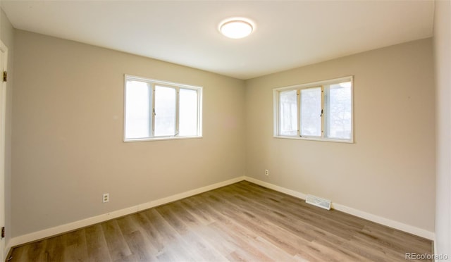 unfurnished room with light wood-type flooring and a wealth of natural light