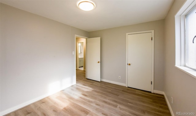 unfurnished bedroom with multiple windows and light wood-type flooring