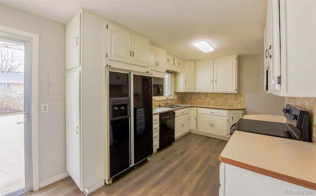 kitchen with sink, dark wood-type flooring, tasteful backsplash, white cabinets, and black appliances