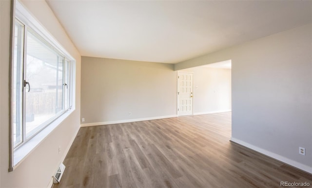 unfurnished room featuring wood-type flooring and a wealth of natural light